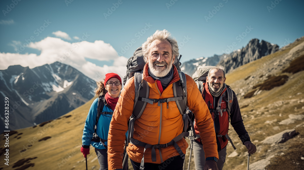 A happy group of elderly people walking on mountain trail in a sunny day. 