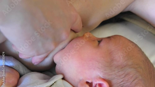 Young mother is breastfeeding her newborn baby. Happy motherhood and lactation