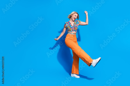 Full body portrait of lovely carefree lady rejoice dancing clubbing empty space isolated on blue color background