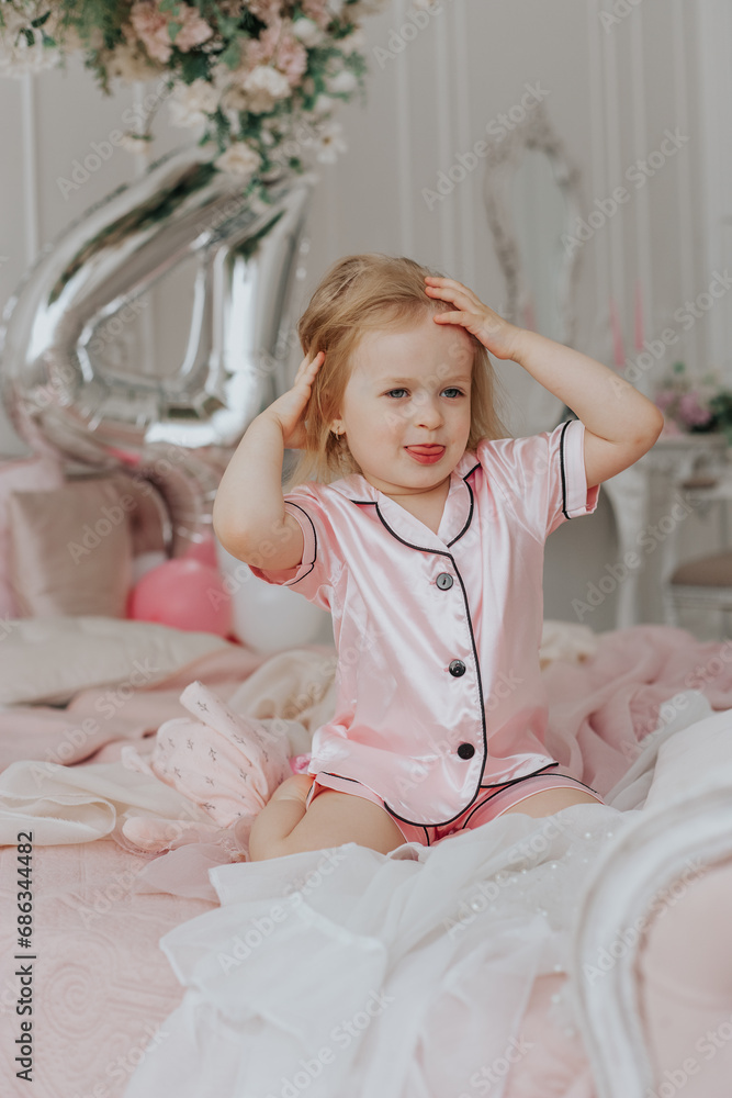 Blonde girl celebrates her 4th birthday in pink pajamas
Blonde girl celebrates her 4th birthday in pink pajamas