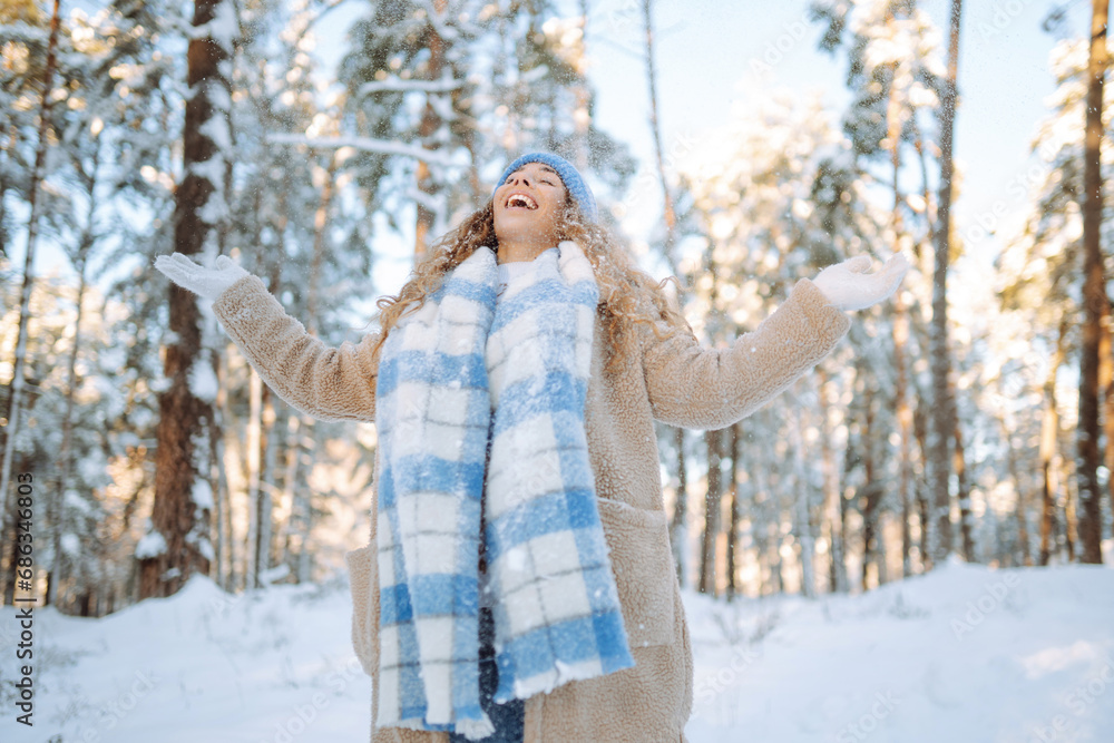 Happy woman wearing scarf and hat on snowy winter day outdoors. Young woman having fun with snow on a frosty day. Walking concept. Happy woman wearing scarf and hat on snowy winter day outdoors. Young woman having fun with snow on a frosty day. Walking concept.