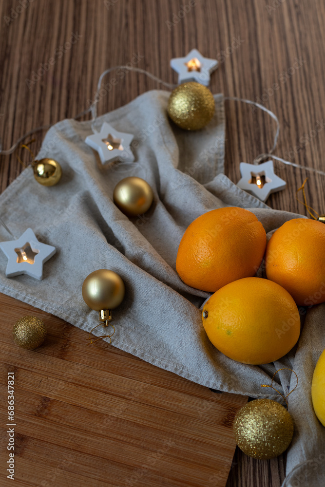 New Year's layout of oranges, board, napkins, garlands and balloons on the kitchen table.Preparations for the holiday.Preparing for the celebration of Christmas.The concept of a cozy kitchen New Year's layout of oranges, board, napkins, garlands and balloons on the kitchen table.Preparations for the holiday.Preparing for the celebration of Christmas.The concept of a cozy kitchen