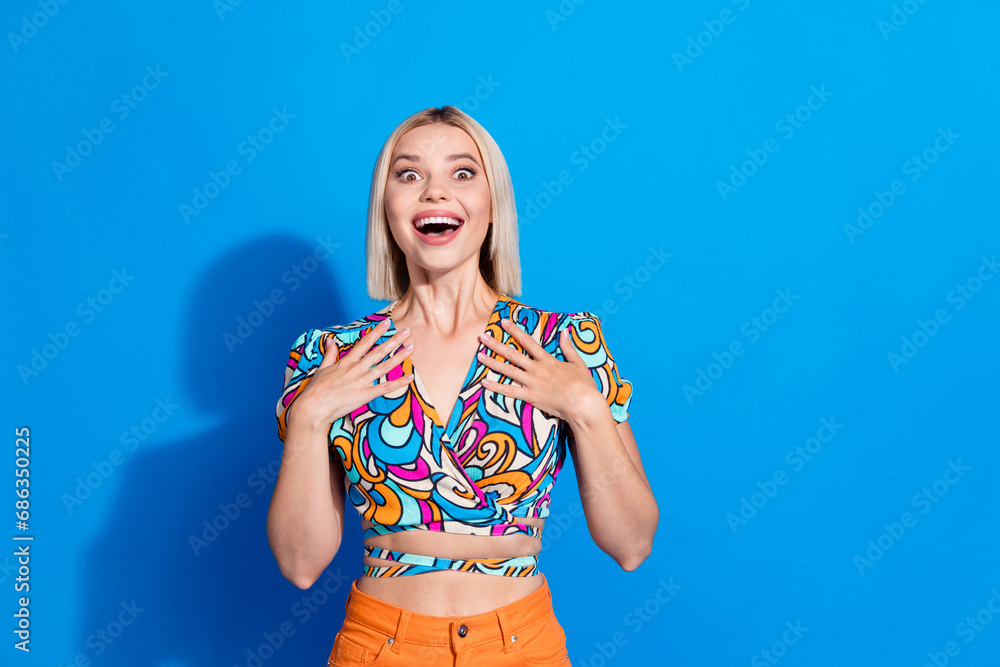 Portrait of gorgeous astonished girl hands touch chest cant believe empty space ad isolated on blue color background Portrait of gorgeous astonished girl hands touch chest cant believe empty space ad isolated on blue color background