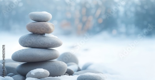 Stone, pebbles stack tower against a snowy outdoor winter background. copy space for text, advertising, message, and logo. concept of balance, yoga, meditation, peace, serenity, tranquility