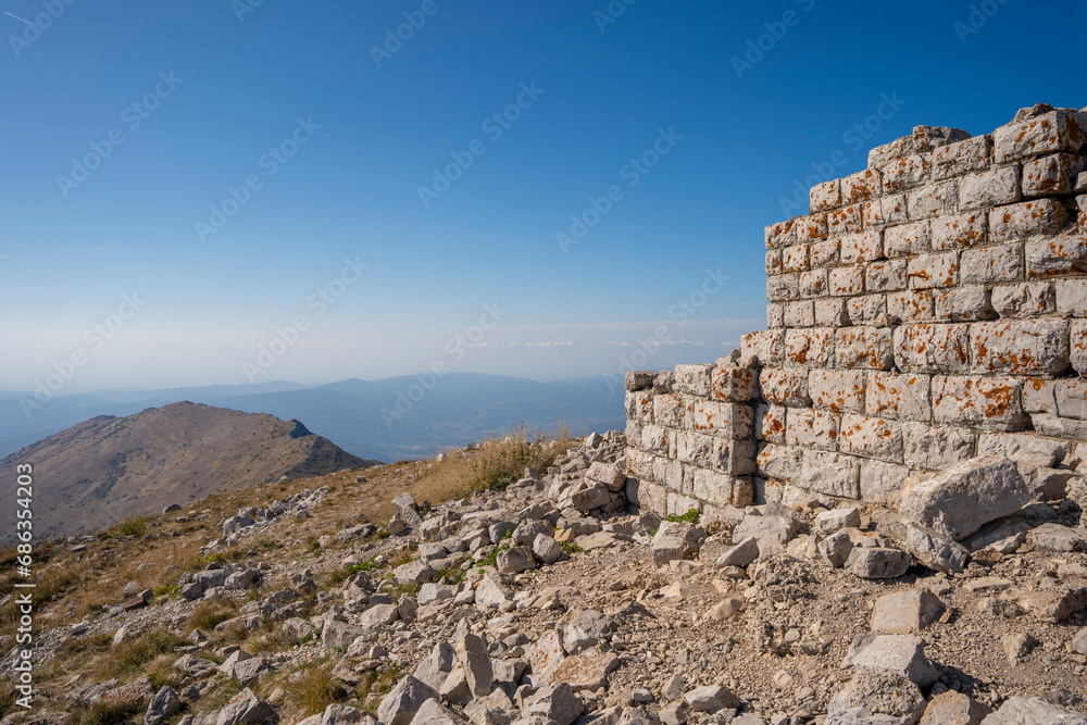 Remains of an old church on the hill of Rtanj mountain with a cloudy sky in the distance