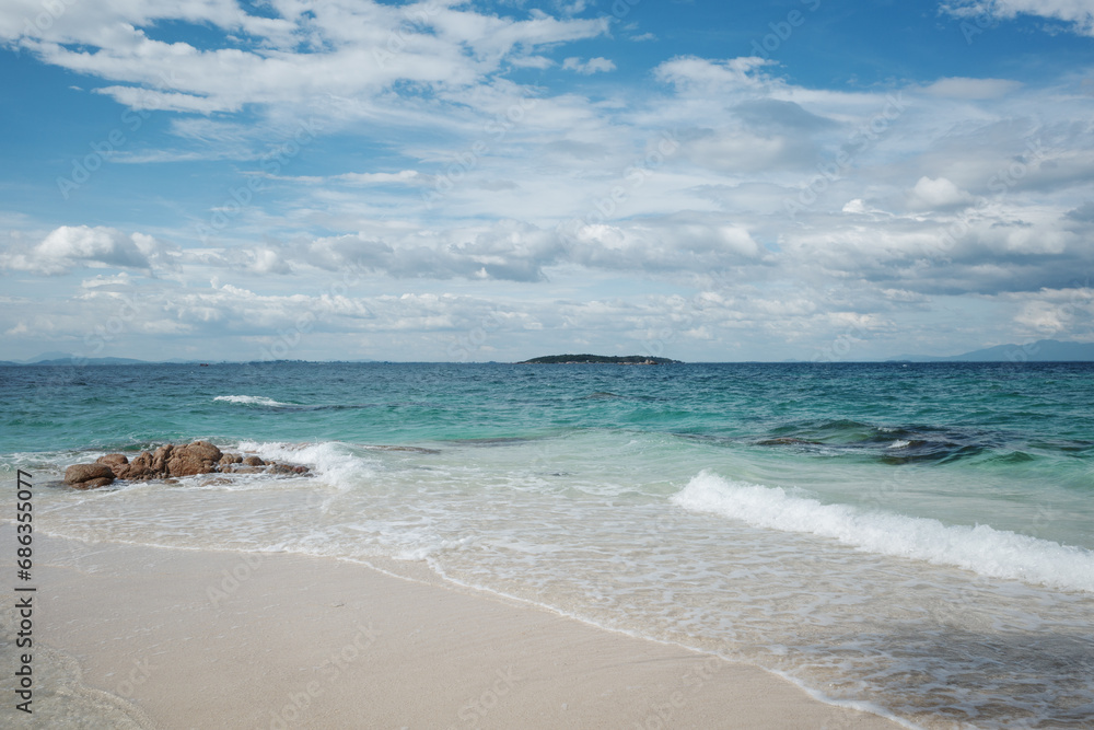 Outdoor scenery view over sea waves with clear water crushing over the rocks during beautiful sunny day. 