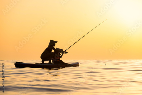 a woman with a child on a sup board in the sea swim against the background of a beautiful sunset, Standup paddleboarding
