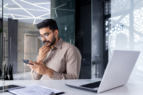 Canvas Print Businessman thinking while sitting inside office at table, man is concentrating