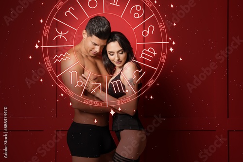 Passionate young couple and Zodiac wheel on red background. Sexual compatibility horoscope