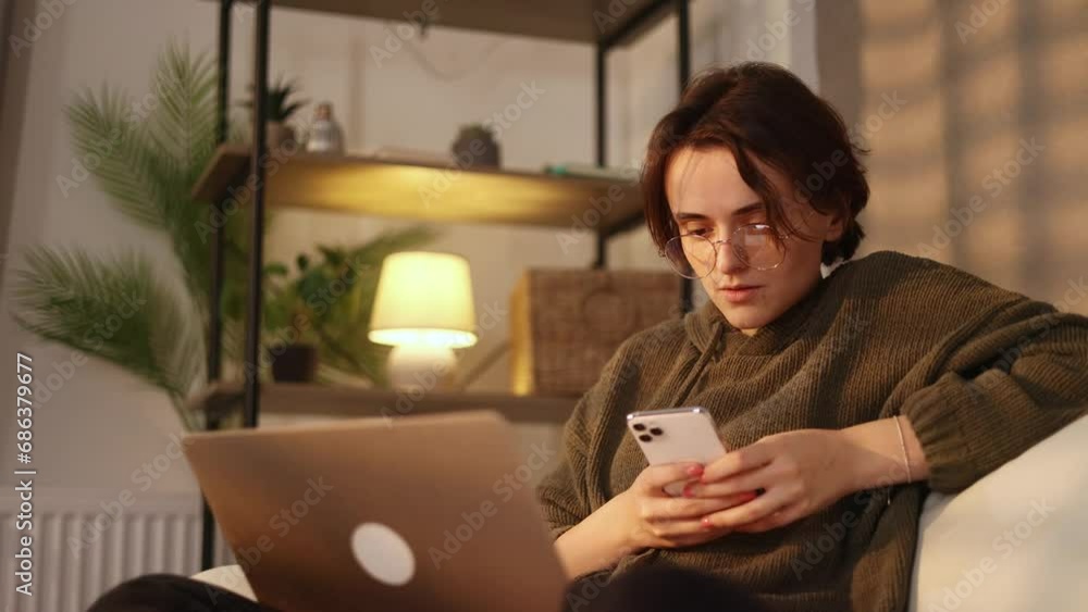 Portrait of creative young freelancer businesswoman have break using social media application on smartphone texting messages receive news check email sitting at couch in the home indoors Portrait of creative young freelancer businesswoman have break using social media application on smartphone texting messages receive news check email sitting at couch in the home indoors