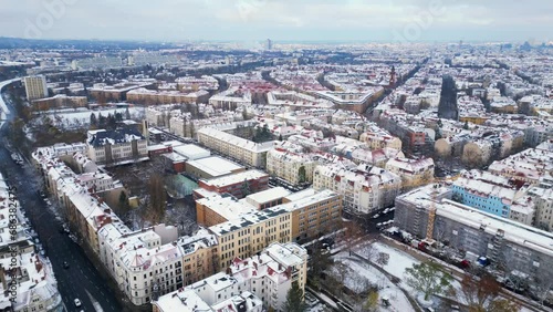Snowy winter Berlin Snow roofs Cloudy sky. Smooth aerial top view flight drone photo