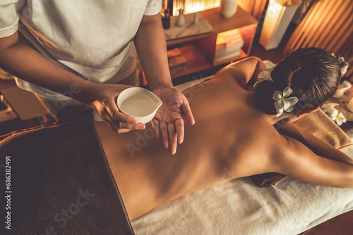Masseur hands pouring aroma oil on woman back. Masseuse prepare oil massage procedure for customer at spa salon in luxury resort. Aroma oil body massage therapy concept. Quiescent photo