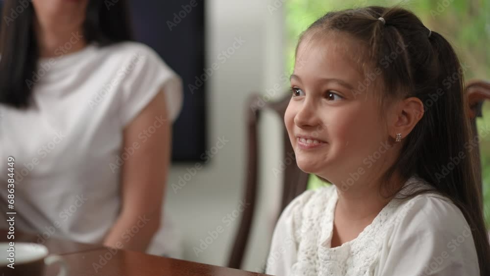 In a playful, comic form, the mother limits her daughters consumption of sweets. Mother and daughter spend leisure time in a modern house sitting at the table In a playful, comic form, the mother limits her daughters consumption of sweets. Mother and daughter spend leisure time in a modern house sitting at the table
