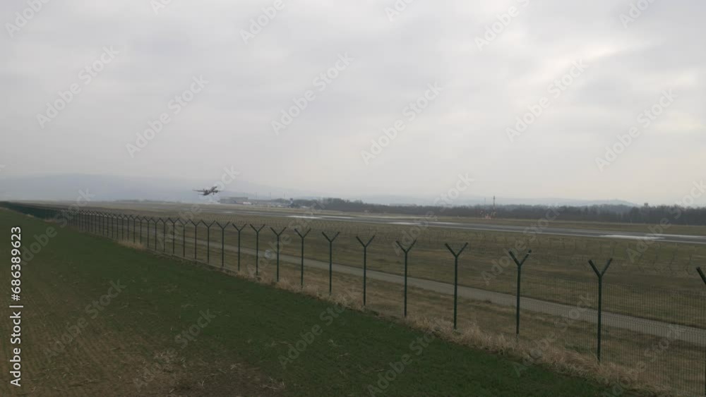 Airplane taking off from the airport runway and rising to the sky on a cloudy day. Fixed frame Airplane taking off from the airport runway and rising to the sky on a cloudy day. Fixed frame