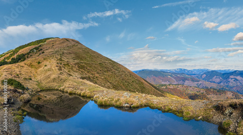 Small picturesque lake with clouds reflections at the  Strymba Mount. Beautiful autumn day in Carpathian Mountains near Kolochava village  Transcarpathia  Ukraine.