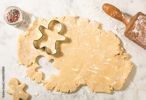 Sugar cookie dough with snowman cookie cutters and rolling pin photo