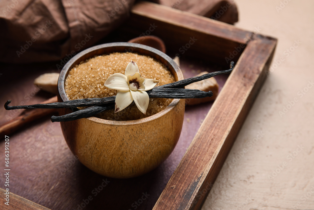 Bowl with aromatic vanilla sugar, flower and sticks on beige background Bowl with aromatic vanilla sugar, flower and sticks on beige background
