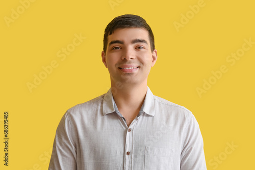 Happy young man on yellow background, closeup