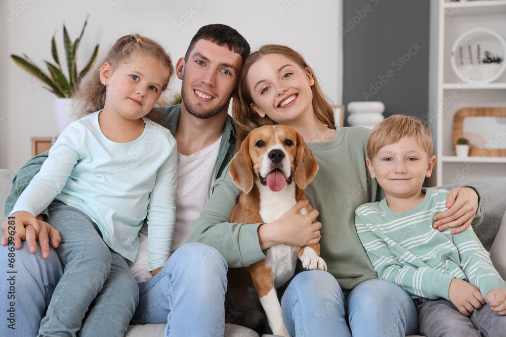 Little children with their parents and cute Beagle dog sitting on sofa at home Little children with their parents and cute Beagle dog sitting on sofa at home