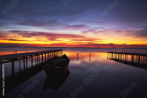 Obraz na płótnie boat at sunrise on the lake w salonie