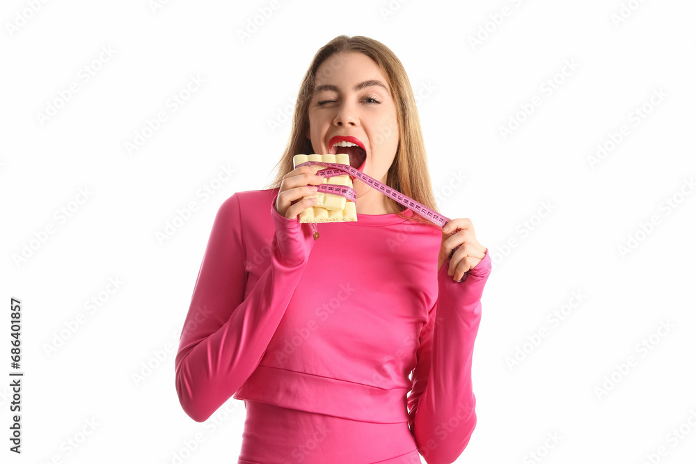 Young woman with white chocolate bar and tape measure on light background Young woman with white chocolate bar and tape measure on light background