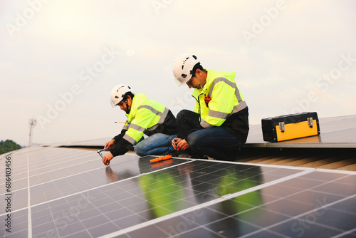 Two engineers installed solar cell farm power plant eco-technology on the roof. Renewable and Sustainable energy