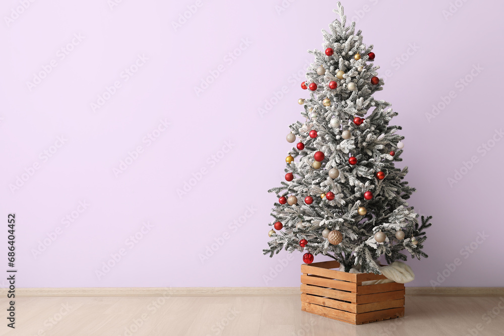 Fir tree decorated with beautiful Christmas balls near color wall