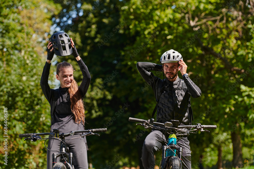 A blissful couple, adorned in professional cycling gear, enjoys a romantic bicycle ride through a park, surrounded by modern natural attractions, radiating love and happiness