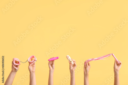 Female hands with different sex toys on color background