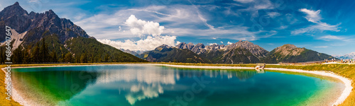 High resolution stitched alpine summer panorama with reflections in a lake at Serles cable car station, Mieders, Stubaital valley, Innsbruck, Austria