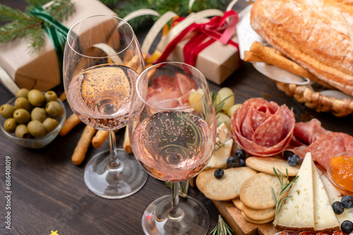 festive aperitif or party two glasses of champagne, Prosecco or rosé wine with cold meat appetizers cheeses and olives photo