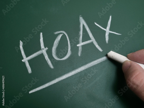 Hoax, text written on chalkboard, fake news gossip issue