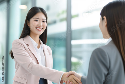 Female Asian businesswomen shaking hands after deal
