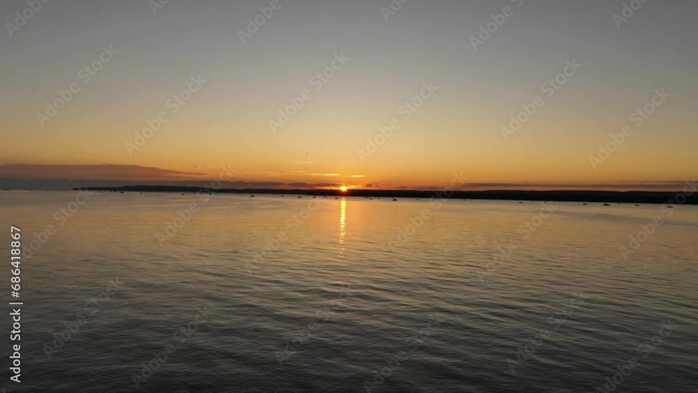 Sunrise swimming long distance on a lake across big body of water with orange sky aerial view Sunrise swimming long distance on a lake across big body of water with orange sky aerial view