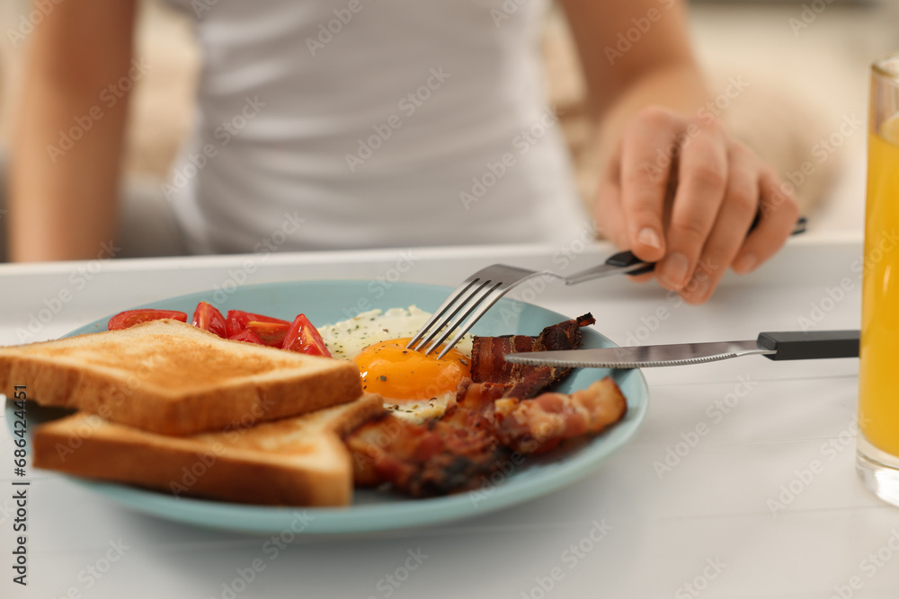 Woman having breakfast on bed at home, closeup