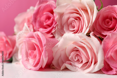 Bouquet of beautiful roses on light table  closeup