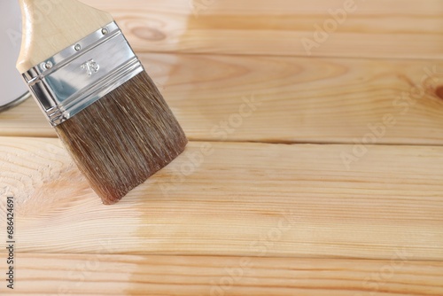 Varnishing surface. Brush on wooden table, space for text