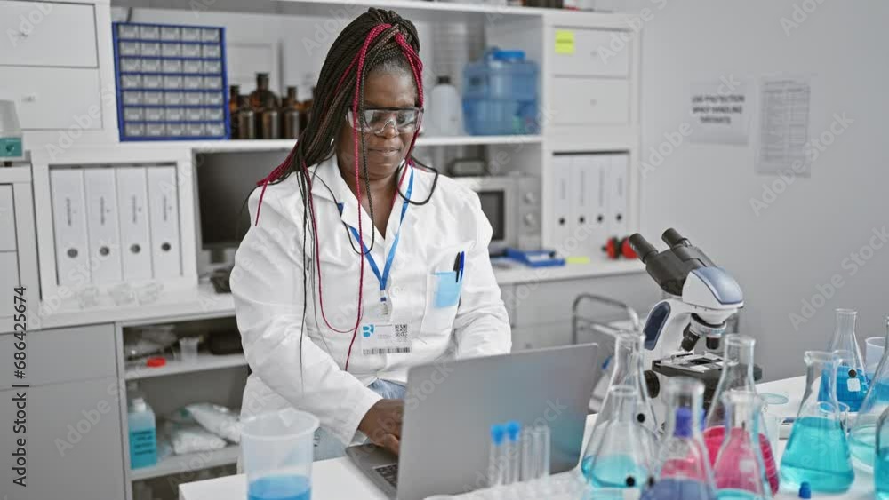 Smiling african american woman scientist takes a stretch break from lab analysis, arms reaching wide, glasses off and laptop at bay. Smiling african american woman scientist takes a stretch break from lab analysis, arms reaching wide, glasses off and laptop at bay.