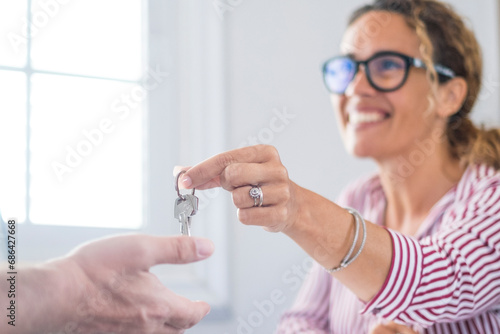 Crop close up of realtor give keys to man buyer or renter buying first home from agency. Real estate agent or broker congratulate male tenant with house or flat purchase. Ownership, rental concept..