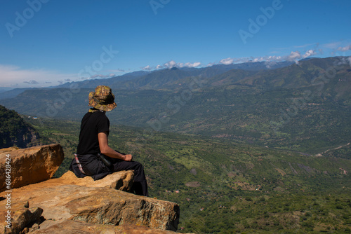 man sitting watching the mountains