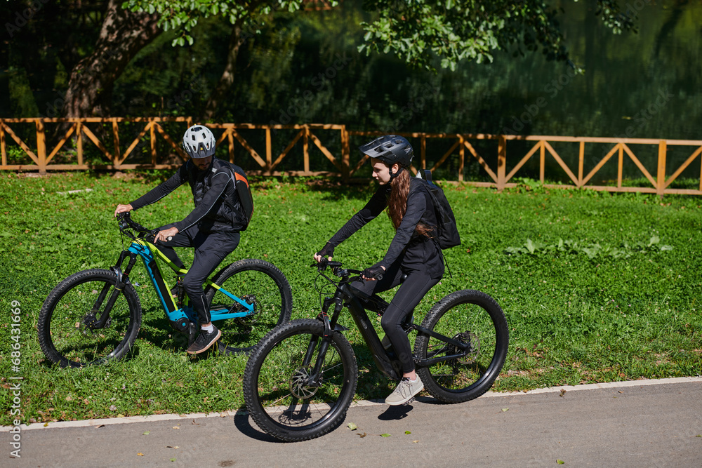 Fototapeta premium A blissful couple, adorned in professional cycling gear, enjoys a romantic bicycle ride through a park, surrounded by modern natural attractions, radiating love and happiness
