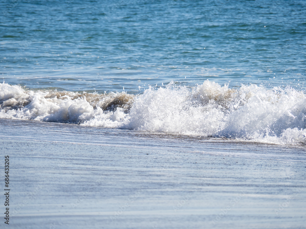 Fototapeta premium 青い海の砂浜の波打ち際。 