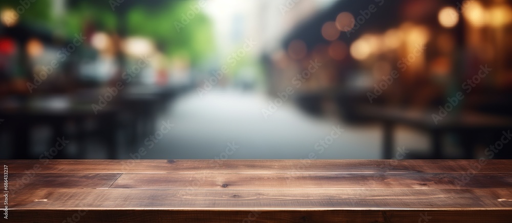 Blur background with bokeh image for product display montage on an empty brown wooden table in a coffee shop