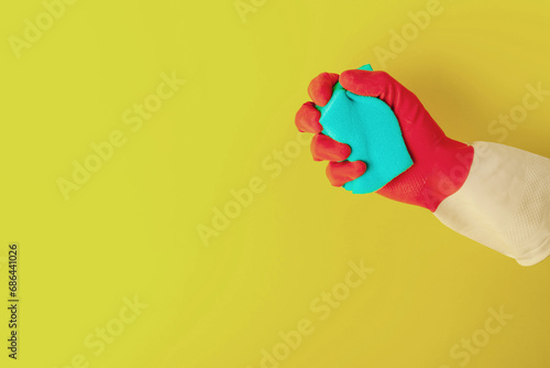 Hand in a rubber glove holds a sponge