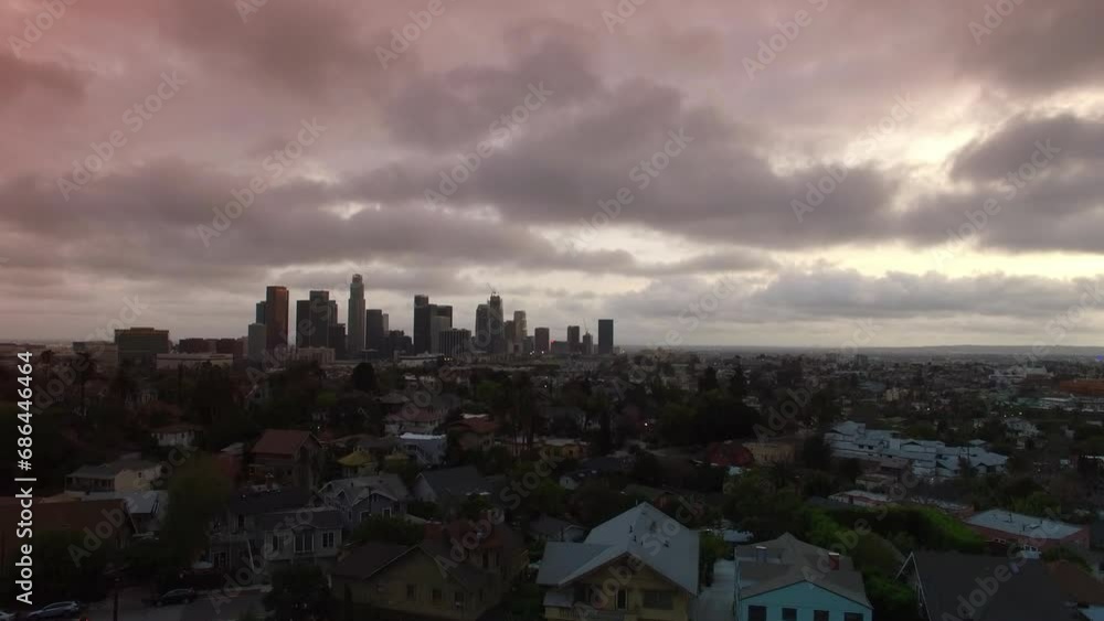 Aerial Upward Beautiful Shot Of Modern Buildings In Downtown Amidst Residential Roofed Houses Under Cloudy Sky In City - Los Angeles, California Aerial Upward Beautiful Shot Of Modern Buildings In Downtown Amidst Residential Roofed Houses Under Cloudy Sky In City - Los Angeles, California