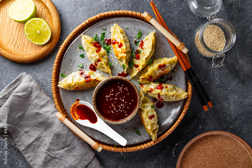 Asian dumplings with hot sauce on the grey background top view - obrazy, fototapety, plakaty 