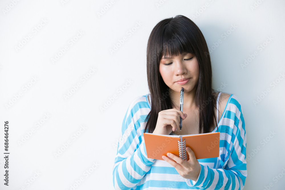 Young Asian woman holding notepad and pen Young Asian woman holding notepad and pen