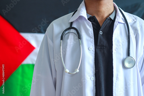 Male doctor with stethoscope on neck standing confidently with Palestine flag on the background