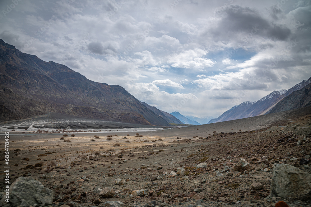 Scenic view of Himalayas and Ladakh ranges. Beautiful barren hills in Ladakh with dramatic clouds in the background.  View from the road from Nubra Valley to Turuk. Siachen area in Leh Ladakh.