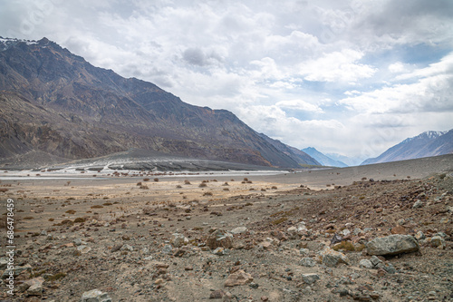 Scenic view of Himalayas and Ladakh ranges. Beautiful barren hills in Ladakh with dramatic clouds in the background. View from the road from Nubra Valley to Turuk. Siachen area in Leh Ladakh.